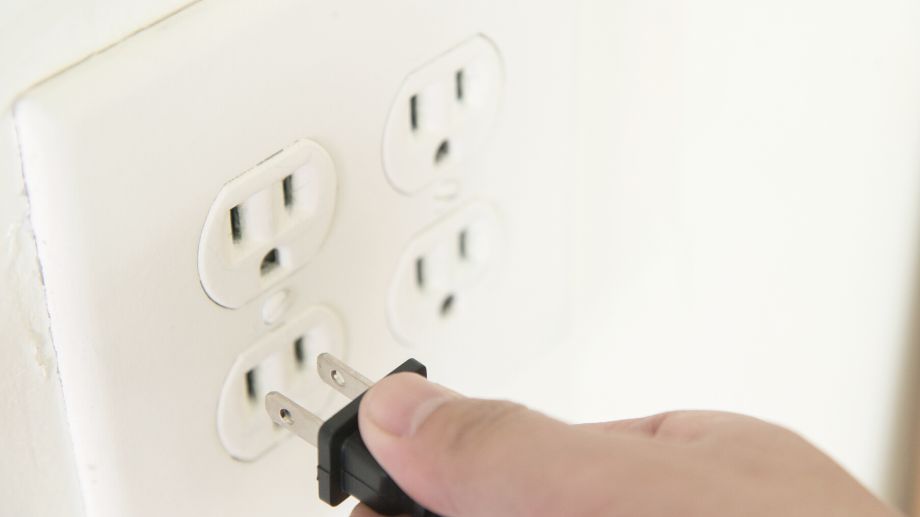 Someone plugging in a power cord